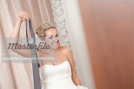 bride playing with necktie