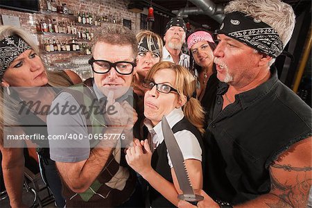 Scared geek couple in bar surrounded by tough gang