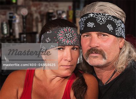Serious middle aged couple in bandannas at a bar
