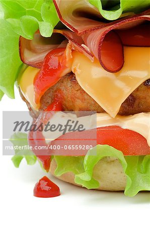 Tasty Juicy Hamburger with Bacon, Beef, Cheese, Tomato, Lettuce, Mayonnaise and Drop of Ketchup closeup on white background