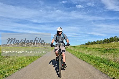 Forest, field, village and mountain biker on a background beautiful sky.