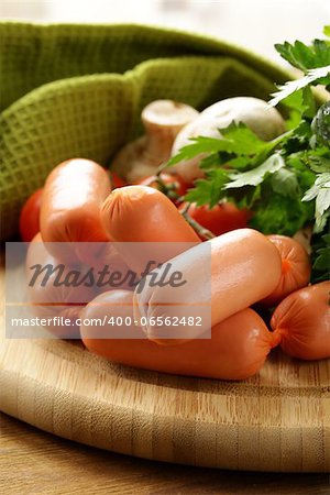 fresh sausages and parsley on wooden cutting board