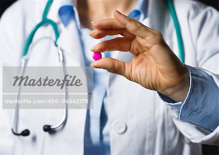 Closeup on medical doctor woman showing pills