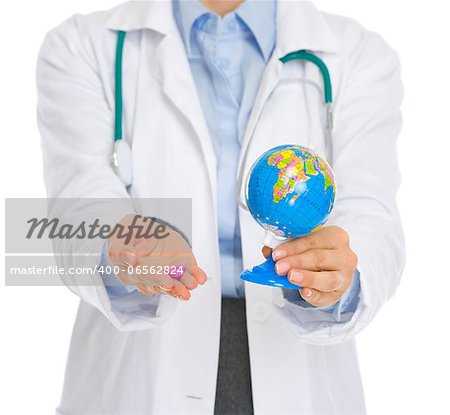 Closeup on medical doctor woman holding pills and globe