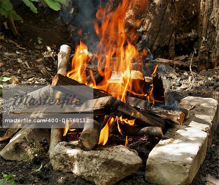 Camping Fire into Stones closeup outdoors
