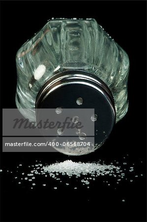 Pile of spilled salt and saltshaker black isolated
