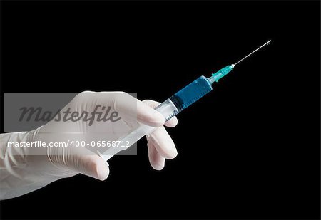 Hand hold medical syringe. Black isolated studio shot.