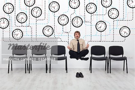 Expert time management - businessman controlling lots of wall clocks