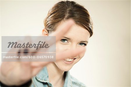 Portrait of Teenage Girl Making the Peace Sign with Her Fingers, in Studio