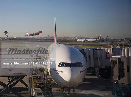 Boeing 777-300 ER jet airliner of Emirates Airline at gate, Emirates and Virgin Blue planes behind, Sydney Airport, Australia, Pacific