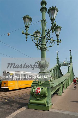 Tram and cyclist on Independence Bridge spanning Danube River, Budapest, Hungary, Europe Tram and cyclist on Independence Bridge spanning Danube River, Budapest, Hungary, Europe