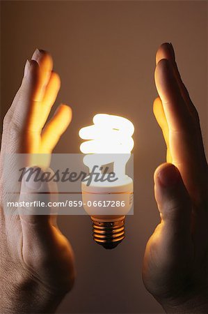Hands With Compact Fluorescent Light Bulb