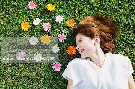 Woman With Flowers Laying Down On the Grass Woman With Flowers Laying Down On the Grass
