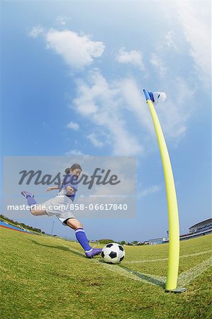 Woman In Soccer Uniform Kicking a Ball