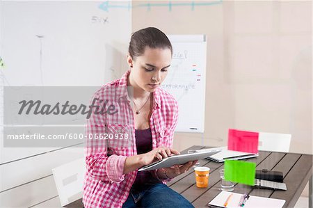 Young Woman Working in an Office, Looking Through Glass Board, Germany