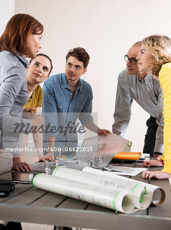 Business People in Meeting Looking at Plans and Model of Windmill