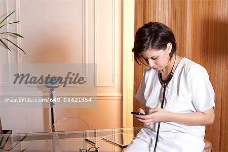 Doctor using cell phone in office Doctor using cell phone in office