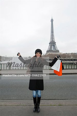 Woman with shopping bags by Eiffel Tower