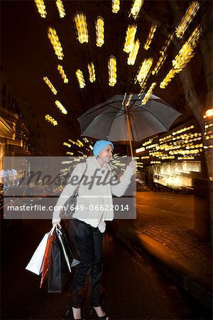 Woman under umbrella on city street