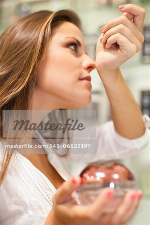 Woman trying on fragrances in store