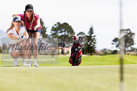 Women playing golf on course