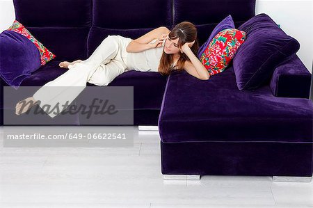 Woman talking on cell phone on sofa