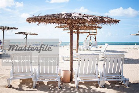 Lawn chairs and umbrella on beach