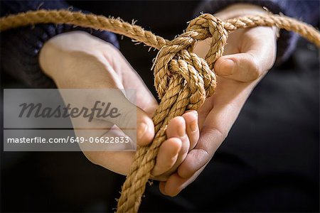 Student tying sheet bend knot in rope