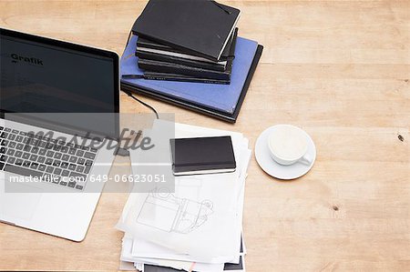 Laptop with books and coffee cup