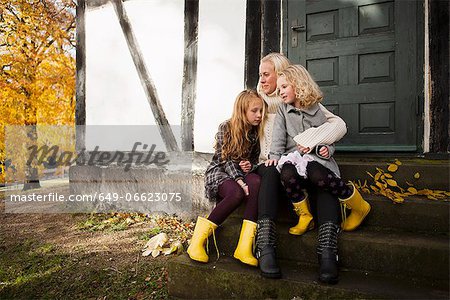 Mother and daughters sitting outdoors