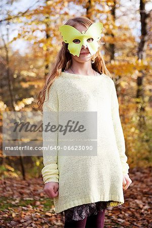 Girl wearing butterfly mask in park