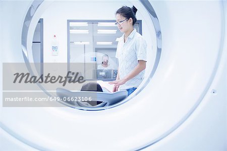 Technician with patient in CT scanner Technician with patient in CT scanner