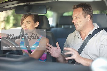 Father teaching teenage daughter driving