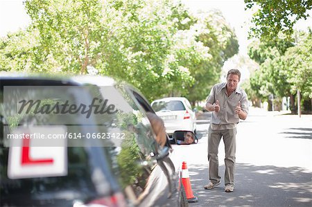 Father teaching teenage daughter driving