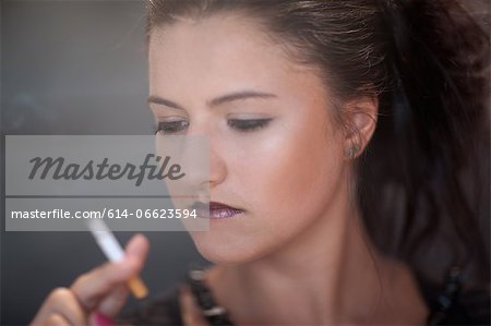 Teenage girl in dark makeup smoking