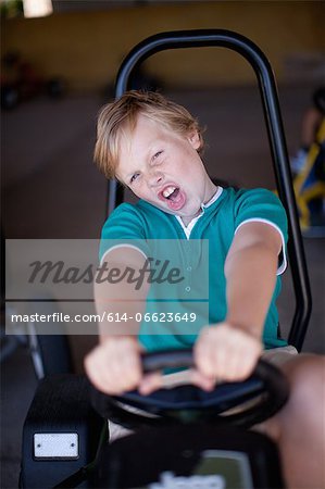 Boy riding go-kart in garage