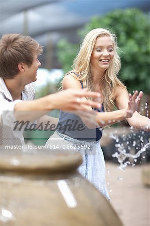 Man splashing girlfriend in fountain