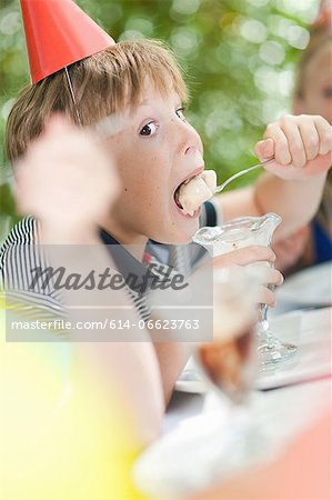 Boy having ice cream sundae at party