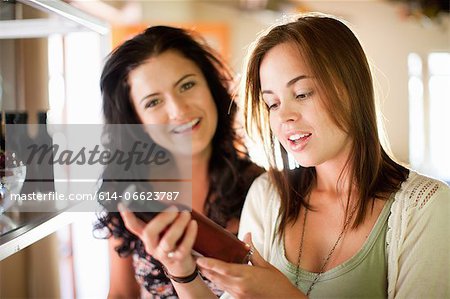 Women reading vinegar bottle in grocery