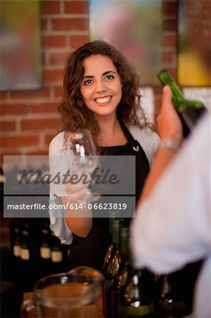 Server offering glass for wine tasting