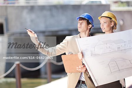 Business people reading blueprints