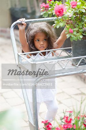Girl pushing cart in plant nursery