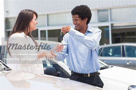 Woman buying new car from salesman
