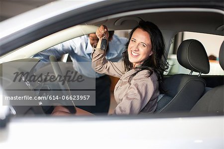 Woman buying new car from salesman