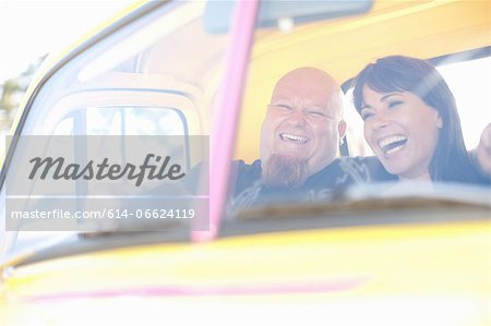 Couple laughing in colorful car