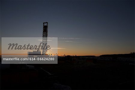 Silhouette of oil well in dry landscape Silhouette of oil well in dry landscape