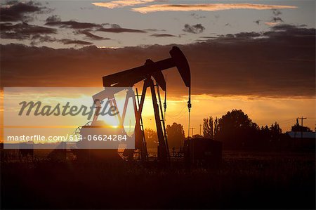 Silhouette of oil wells at sunset Silhouette of oil wells at sunset
