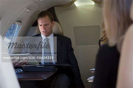 Businessman using tablet on airplane