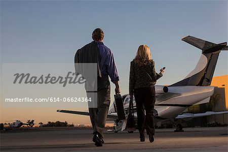 Business people on airplane runway