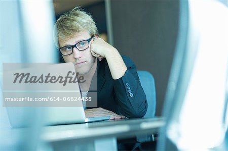 Bored businessman using laptop
